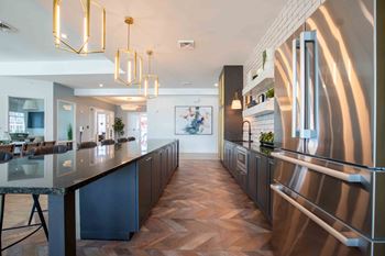 A kitchen with a long counter top and a stainless steel refrigerator